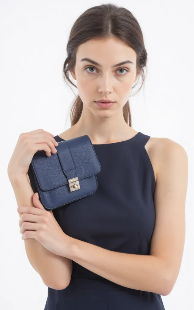 A French female model with a Snap   closure bag, wearing a dress, against a white background, in a front   facing close   up